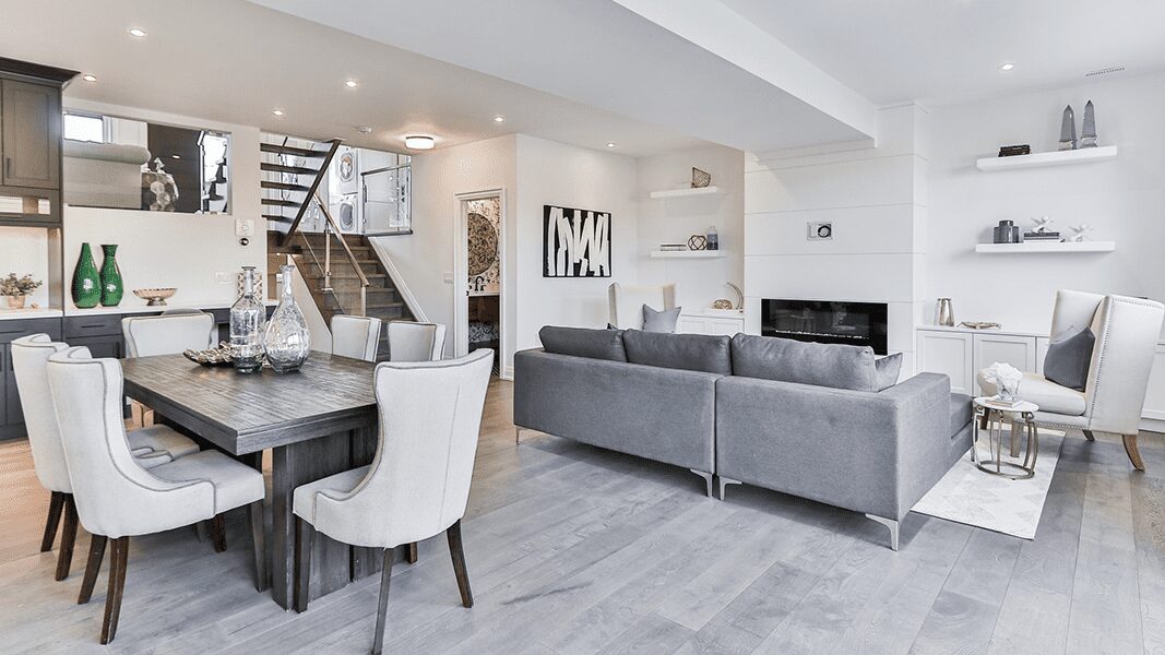 white kitchen and living area with grey loveseat and white chairs